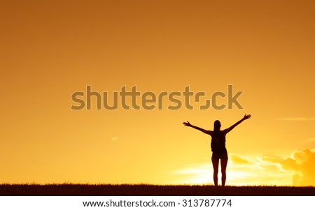 Female hiker with her arms up feeling free.