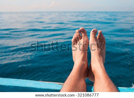 Pair of feet resting on boat.