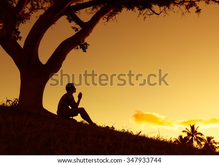 Man praying, meditating in harmony and peace at sunset