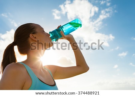 Young female drinking a bottle of water.