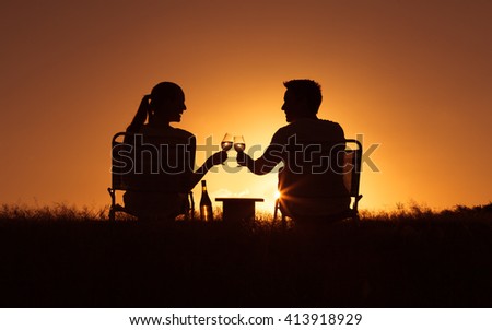 Happy moments. Young couple enjoying a glass of wine in the park.  (Happiness and love concept)