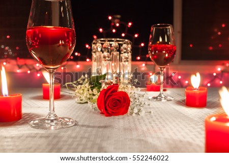 Lovely romantic candle light dinner with focus on red rose.