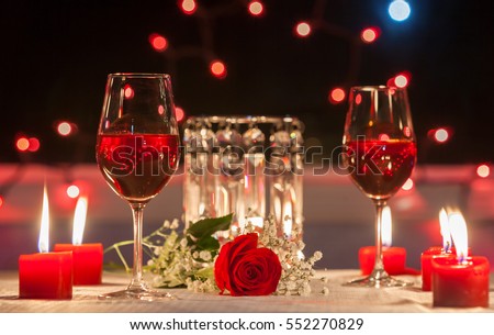 Romantic dinner. Focus on red rose.