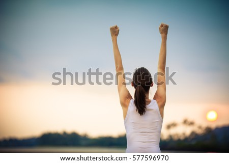 Happy woman with fist in the air celebrating.