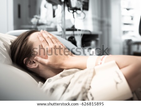 Young woman patient lying at hospital bed feeling sad and depressed worried. Disease feeling sick in health care and clinical attention concept
