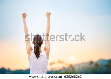 Success and life goals concept. Strong and confident woman with arms in the air.