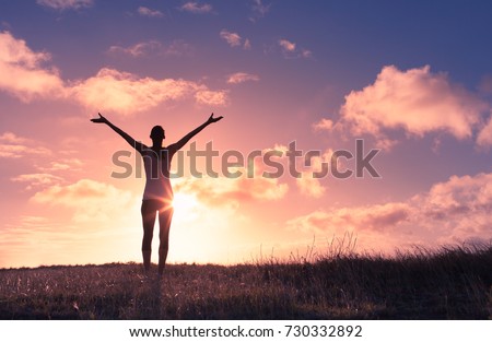 It\'s a beautiful life. Happy woman with arms up in the sunset.
