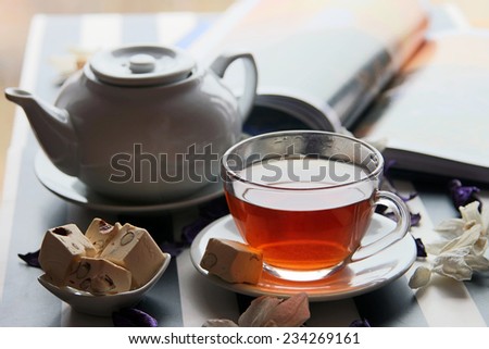 white teapot and  cup of tea with  deserts on the background view from the window