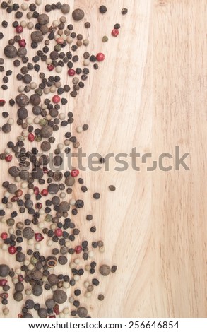 black, white and red pepper peas on the background of wooden boards