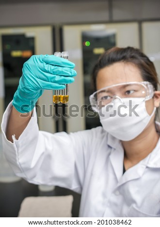 Lady experimenting chemicals in test tubes with blur face