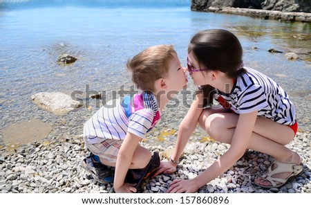 children brother and sister kiss on the beach. boy 5 years. girl 10 years old.