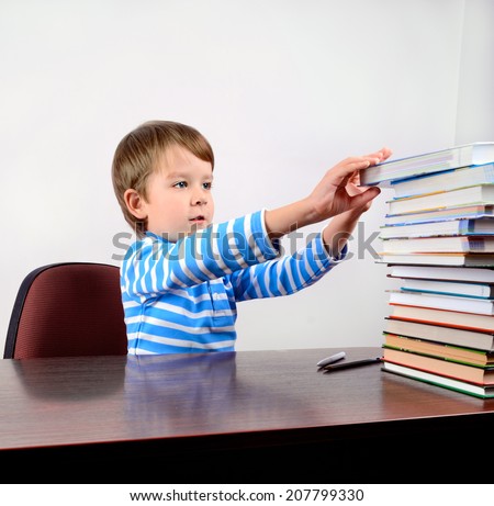 little boy takes a book from the stack square format