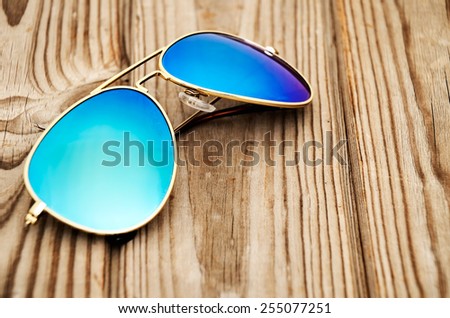 blue mirrored sunglasses on the wooden background close up. horizontal