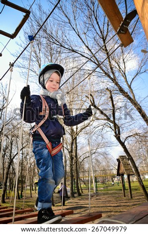 boy going on suspension bridge and looking down. vertical format