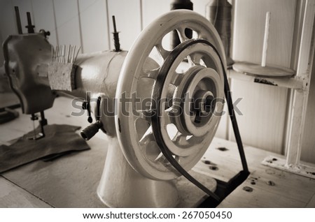 hand wheel old sewing machine. close up, horizontal format, sepia, monochrome