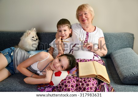 Grandma with grandchildren smiling sitting on the couch horizontal