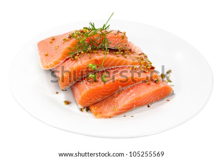 Raw salmon fillet with spices on plate