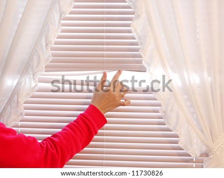 Behind the curtain, looking through a window blind
