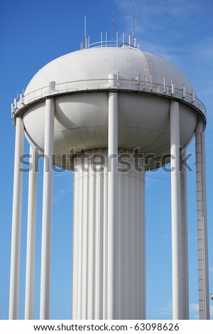 Water tower painted in white against blue sky