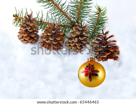 Yellow Christmas ball hanging over pine branch