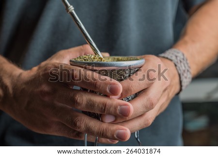 Hands macro holding mate to drink.