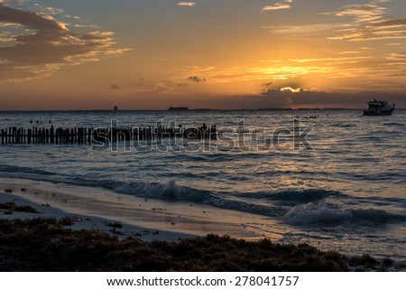 Sunset with people swimming at Caribbean Island. Mexico, Cancun.