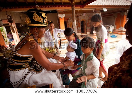 BALI, INDONESIA - MARCH 28: Unidentified child during the ceremonies of Oton - is the first ceremony for baby's on which the infant is allowed to touch the ground on March 28, 2012 on Bali, Indonesia.