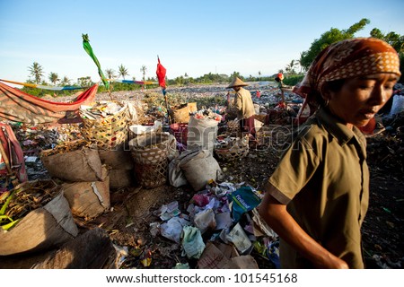 BALI, INDONESIA - APRIL 11: Poor people from Java island working in a scavenging at the dump on April 11, 2012 on Bali, Indonesia. Bali daily produced 10,000 cubic meters of waste.