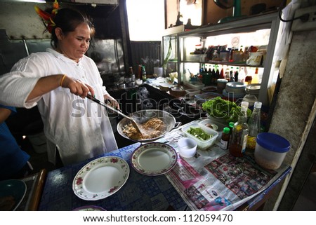 CHANG, THAILAND - JANUARY 23: Unknown vendors prepare food at a street side restaurant on Jan 23, 2012 in Chang, Thai. Government figures indicate more 16,000 registered street vendors in Thailand.