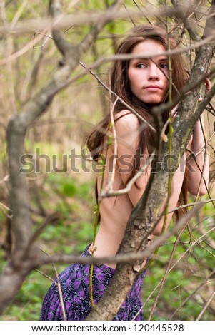 Fashion portrait of young naked woman in the forest