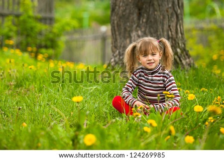 Lovely five-year girl sitting in grass