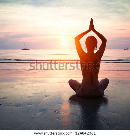 Silhouette Of A Woman Yoga On Sea Sunset.