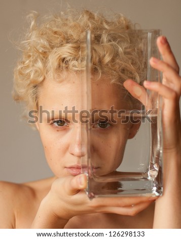 Young girl looks through the empty glass.