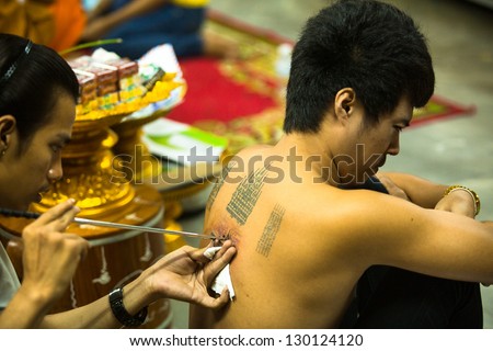NAKHON CHAI, THAILAND - MAR 1: Unidentified monk makes traditional Yantra tattooing on Mar 1, 2012 in Nakhon Chai, Thailand. Yantra tattoo also called Sak Yant, practiced in Southeast Asian countries.