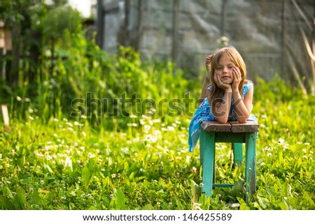 Little girl in the yard of a country house