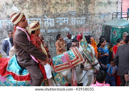 HARIDWAR, INDIA - JANUARY 14: The groom goes to bride, friends are dancing in front of the horse, to delay the moment of betrothal in traditional Indian wedding, January 14, 2009 in Haridwar, India.