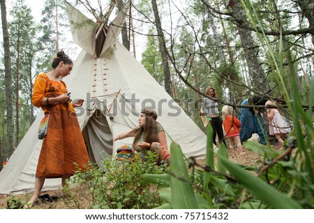 PSKOV REGION, RUSSIA - JULY 19: Members of the Russian Rainbow Family (Youth counterculture 1960\'s: bohemianism, hipster and hippie culture) engaged in a discussion during an annual gathering near Lake Asho on July 19, 2010 in Pskov Region, Russia.