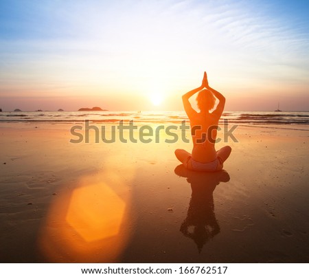 Yoga practicing at sunset, serenity and meditation.