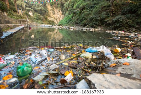 Plastic Contamination into Nature. Garbage and bottles floating on water. Environmental pollution in the Himalayas. Garbage in the water of river Bagmati.