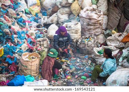 KATHMANDU, NEPAL - DEC 19, 2013: Unidentified people from poorer areas working in sorting of plastic on the dump, Dec 19, 2013 in Kathmandu, Nepal. Only 35% of population have access to adequate sanitation.