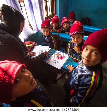 KATHMANDU, NEPAL - DEC 24, 2013: Unknown pupils in English class during preparation of Christmas at primary school, Dec 24, 2013 in Kathmandu, Nepal. Only 50% of  children in Nepal can reach 5th grade.