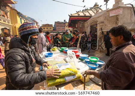 KHATMANDU, NEPAL - DEC 17: Unidentified man sell cement for donations for repairs near stupa Boudhanath during festive solemn Puja of Norbu Rinpoche\'s reincarnations, Dec 17, 2013 in Khatmandu, Nepal.