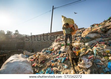 KATHMANDU, NEPAL - DEC 22, 2013: Unidentified man from poorer areas working in sorting of plastic on the dump, Dec 22, 2013 in KTM, Nepal. Only 35% of population have access to adequate sanitation.