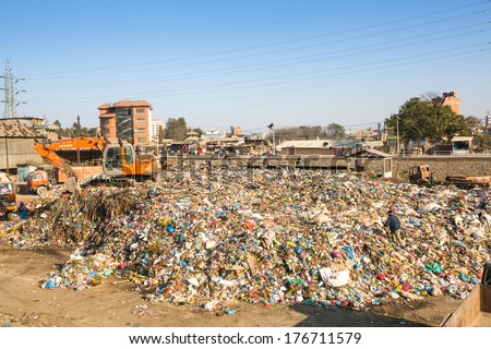 KATHMANDU, NEPAL - DEC 22, 2013: Unidentified people from poorer areas working in sorting of plastic on the dump. Only 35% of population have access to adequate sanitation.