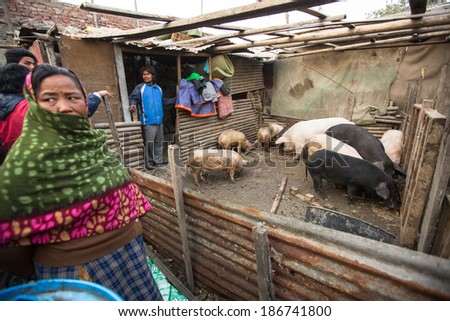 KATHMANDU, NEPAL - DEC 19, 2013: Unidentified local people near their homes in a poor area of the city. The caste system is still intact today but the rules are not as rigid as they were in the past.