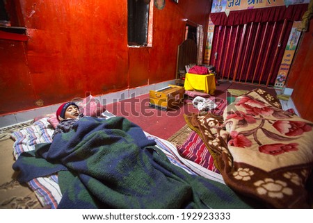 KATHMANDU, NEPAL - DEC 9, 2013: Unknown child sleeping after lesson at Jagadguru School. School established at 2013, to let new generation learn Sanskrit and preserve Hindu culture.