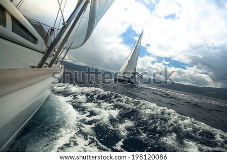 Sailing ship yachts with white sails in the sea in stormy weather Sailing ship yachts with white sails in the sea in stormy weather