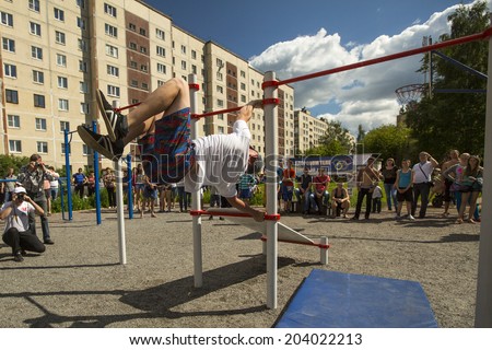TIKHVIN, RUSSIA - JULY 7, 2014: Unidentified participants city competitions in Street workout timed to the celebration of the day of the city of Tikhvin.