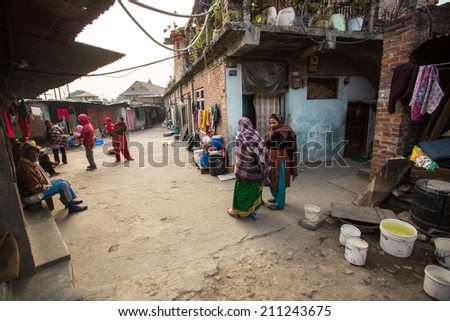 KATHMANDU, NEPAL - DEC 19, 2013: Unidentified local people near their homes in a poor area of the city. The caste system is still intact today but the rules are not as rigid as they were in the past.