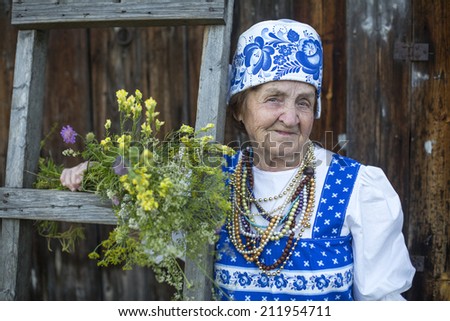 Old woman in russian ethnic clothes, outdoors.